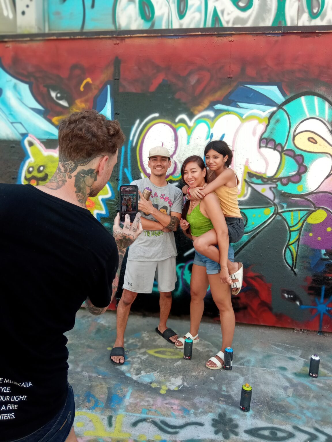Street Artist takes photos of family in front of graffiti