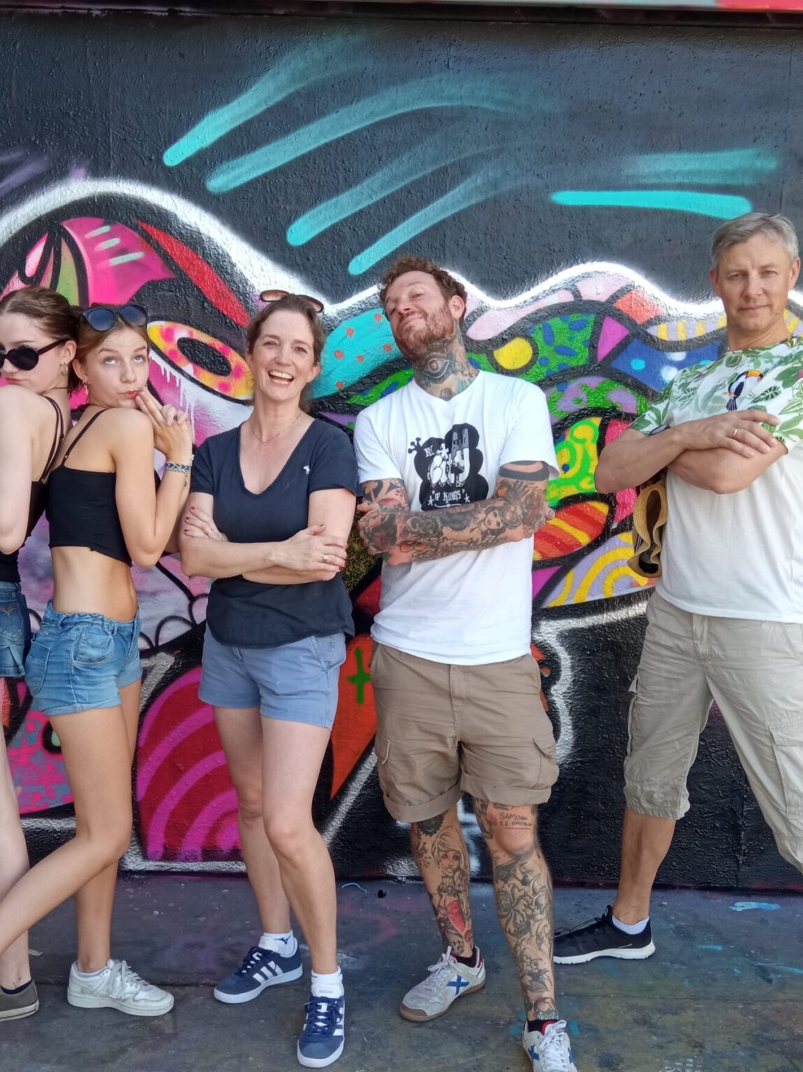 Family in comic pose in front of mural