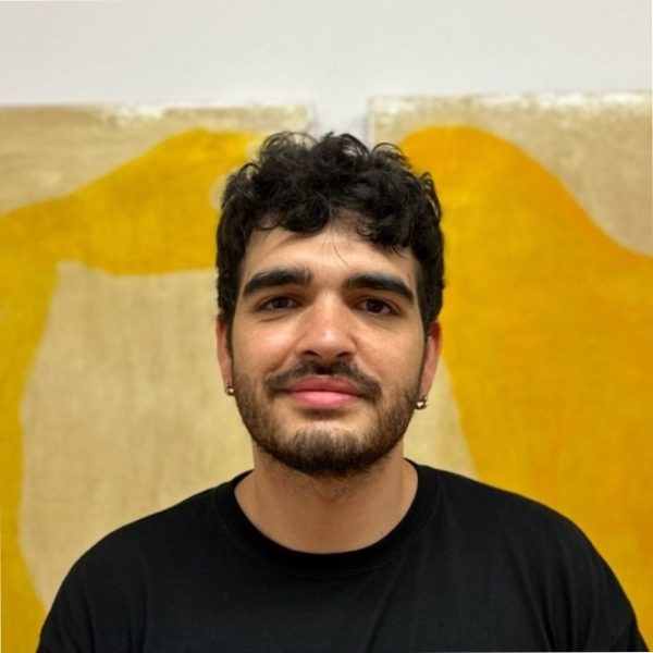 Close up portrait photo of young italian man with art in background and a friendly demeanour